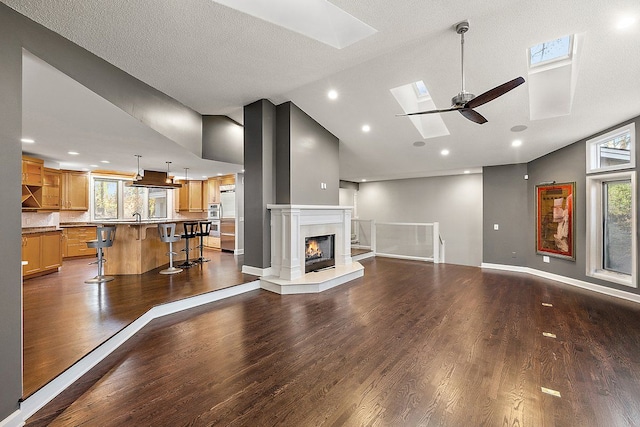 living room with a healthy amount of sunlight, dark wood-type flooring, and high vaulted ceiling