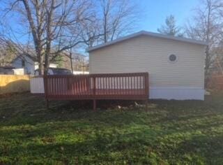 back of house with a yard and a deck