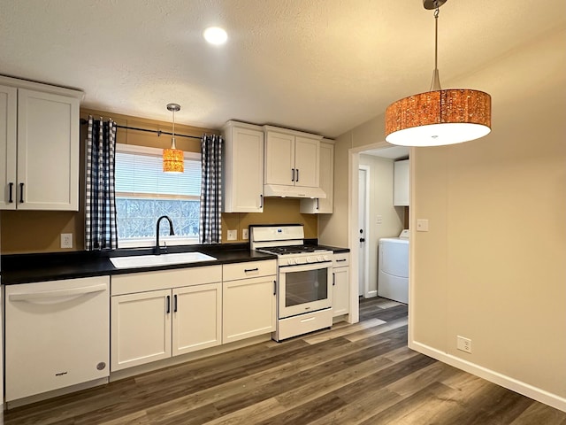 kitchen featuring sink, pendant lighting, white appliances, and washer / dryer