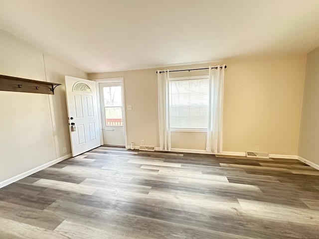 foyer entrance with dark hardwood / wood-style floors and vaulted ceiling