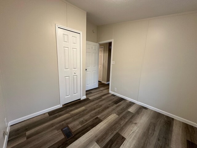 206 Crane St, Union City, MI 49094 - unfurnished bedroom featuring dark wood-style flooring, baseboards, and a closet