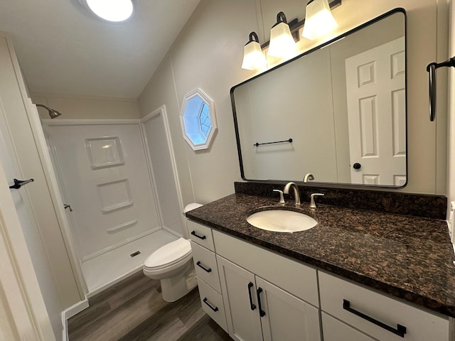 bathroom featuring hardwood / wood-style flooring, vanity, toilet, and a shower