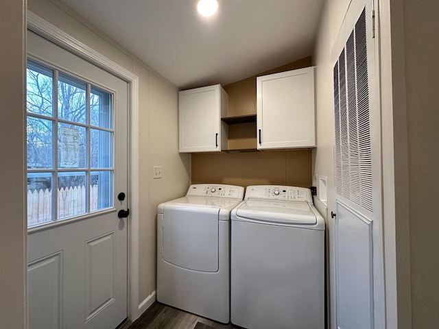 laundry room featuring washing machine and clothes dryer, dark hardwood / wood-style flooring, and cabinets