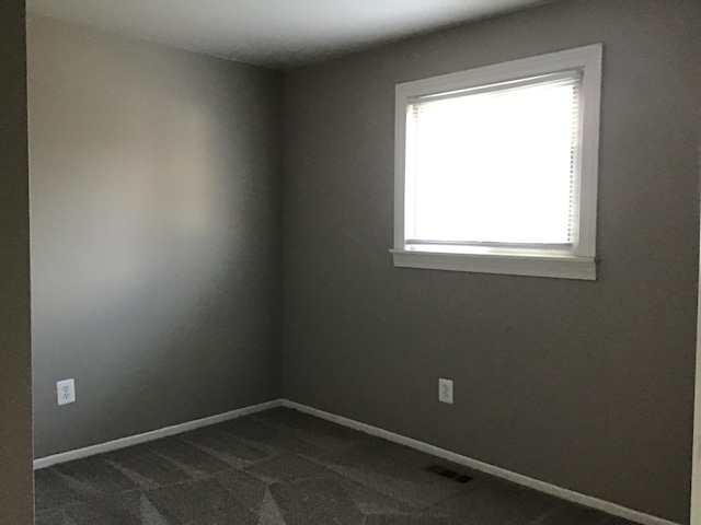 empty room featuring dark colored carpet