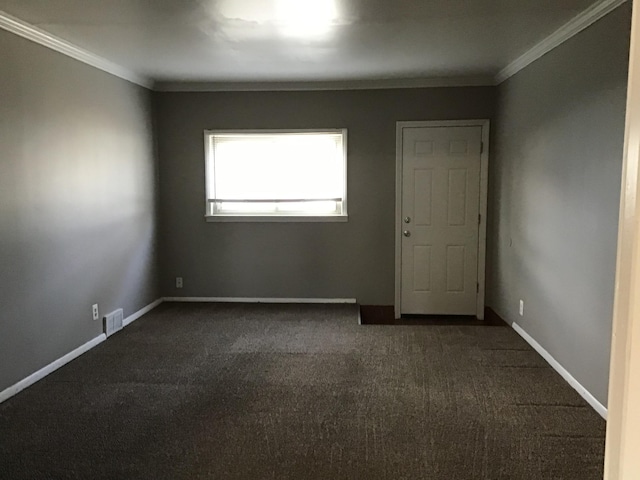 carpeted spare room featuring crown molding