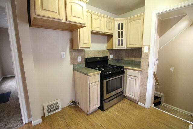 20253 Washtenaw St, Harper Woods, MI 48225 - kitchen with stainless steel range with gas cooktop, backsplash, light wood-style floors, and baseboards