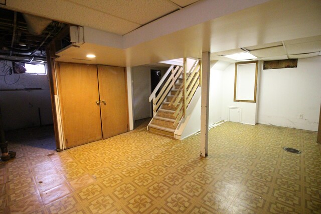 20253 Washtenaw St, Harper Woods, MI 48225 - basement with a paneled ceiling, light flooring, and stairs