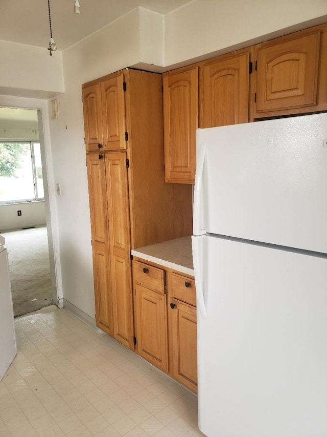 kitchen with light carpet and white fridge