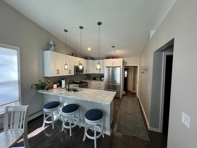 kitchen with appliances with stainless steel finishes, white cabinetry, a wealth of natural light, and pendant lighting