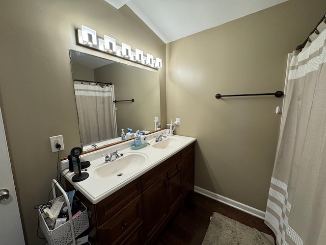 bathroom with vanity, wood-type flooring, and lofted ceiling