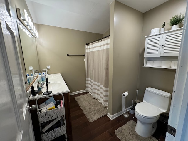 bathroom with a shower with shower curtain, vanity, wood-type flooring, and toilet