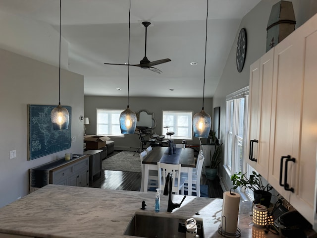 kitchen featuring ceiling fan, pendant lighting, lofted ceiling, and hardwood / wood-style flooring