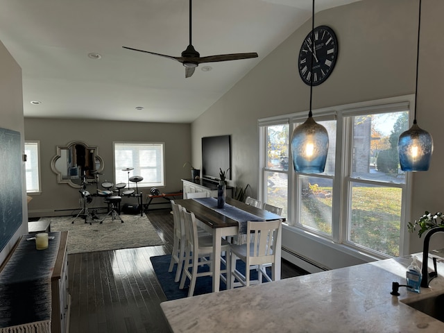 dining area with dark hardwood / wood-style flooring, ceiling fan, sink, a baseboard radiator, and high vaulted ceiling