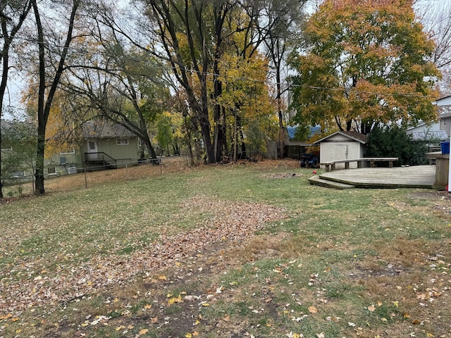 view of yard featuring a deck and a storage unit