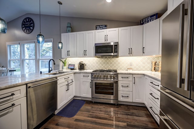 kitchen featuring white cabinets, vaulted ceiling, and high quality appliances