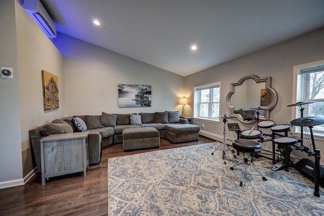 living room featuring dark hardwood / wood-style flooring, lofted ceiling, and an AC wall unit