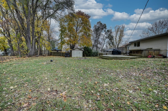 view of yard featuring a storage unit and a wooden deck