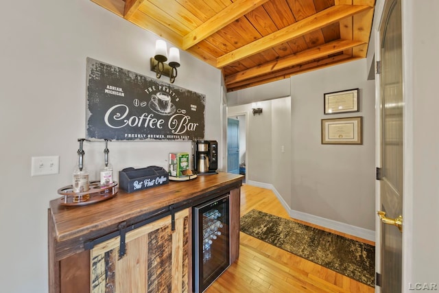 bar featuring wooden counters, beam ceiling, wooden ceiling, light hardwood / wood-style floors, and wine cooler