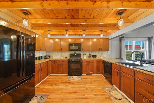 kitchen with backsplash, sink, black appliances, light hardwood / wood-style flooring, and hanging light fixtures