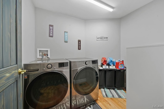 laundry room with washer and clothes dryer and hardwood / wood-style floors