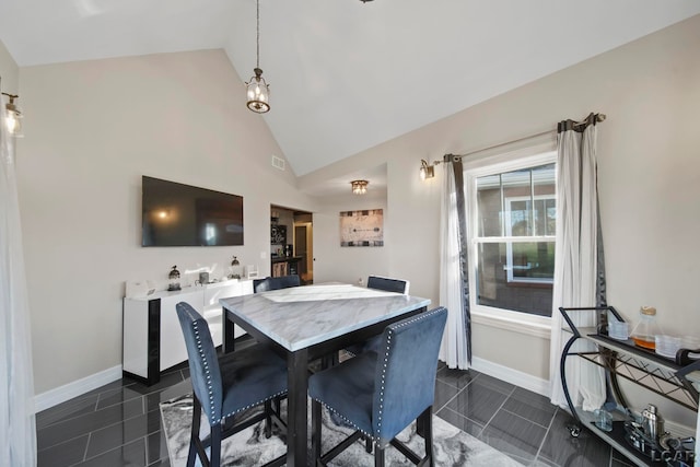 dining room with high vaulted ceiling and dark tile patterned flooring