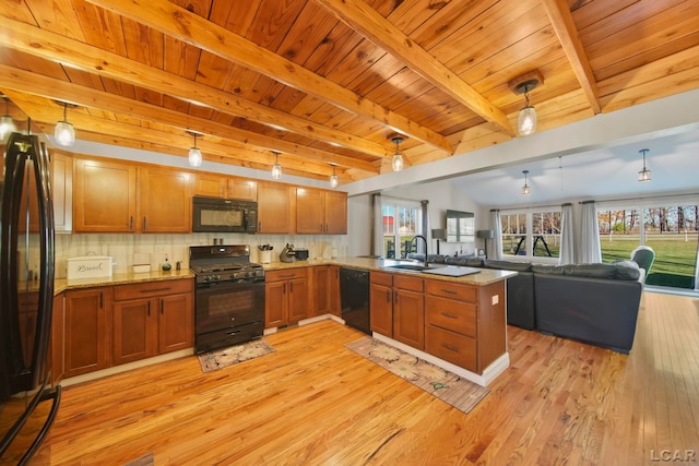 kitchen with kitchen peninsula, sink, black appliances, light hardwood / wood-style flooring, and hanging light fixtures