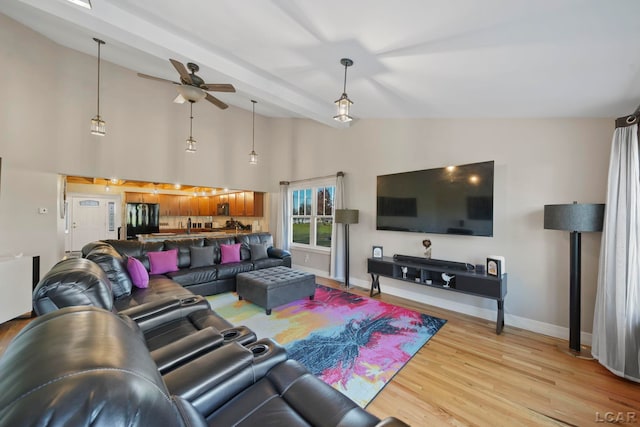 living room featuring beam ceiling, ceiling fan, light hardwood / wood-style flooring, and high vaulted ceiling