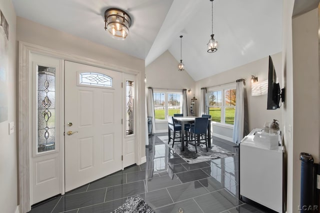 foyer with high vaulted ceiling and dark tile patterned floors