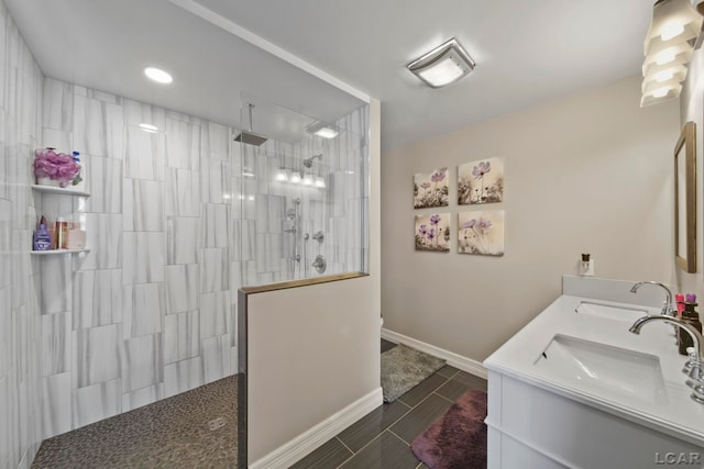 bathroom with tile patterned flooring, vanity, and tiled shower