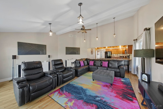 living room with beam ceiling, ceiling fan, high vaulted ceiling, and light hardwood / wood-style floors