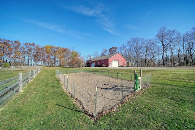 view of yard featuring a garage, a rural view, and an outdoor structure