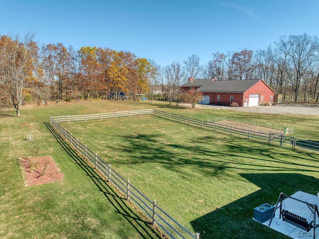 view of yard featuring an outbuilding, a rural view, and a garage