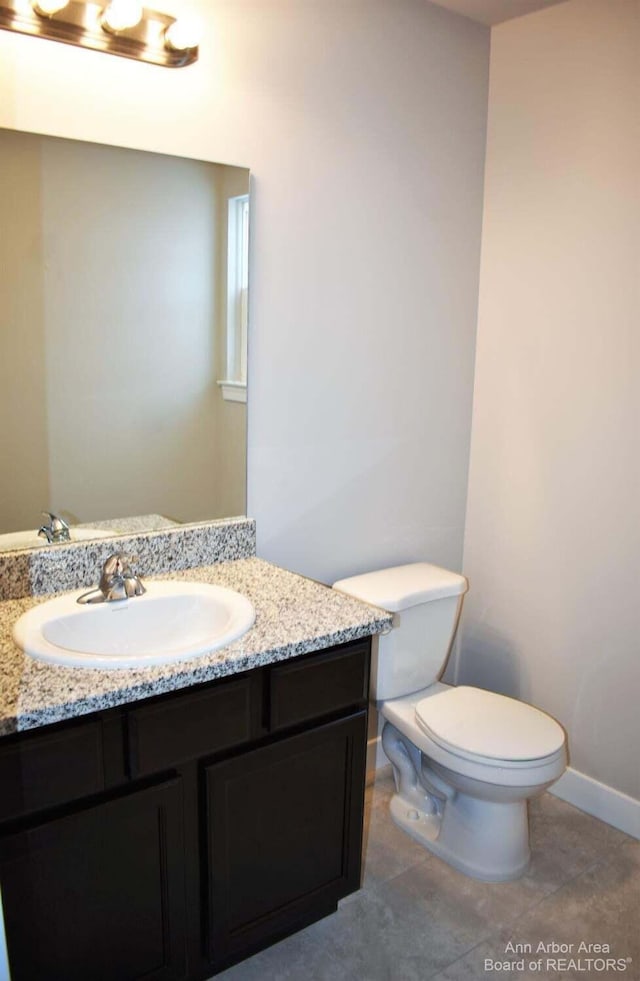 bathroom featuring vanity, toilet, and tile patterned flooring