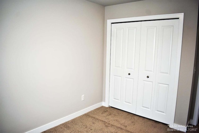 unfurnished bedroom featuring carpet floors and a closet