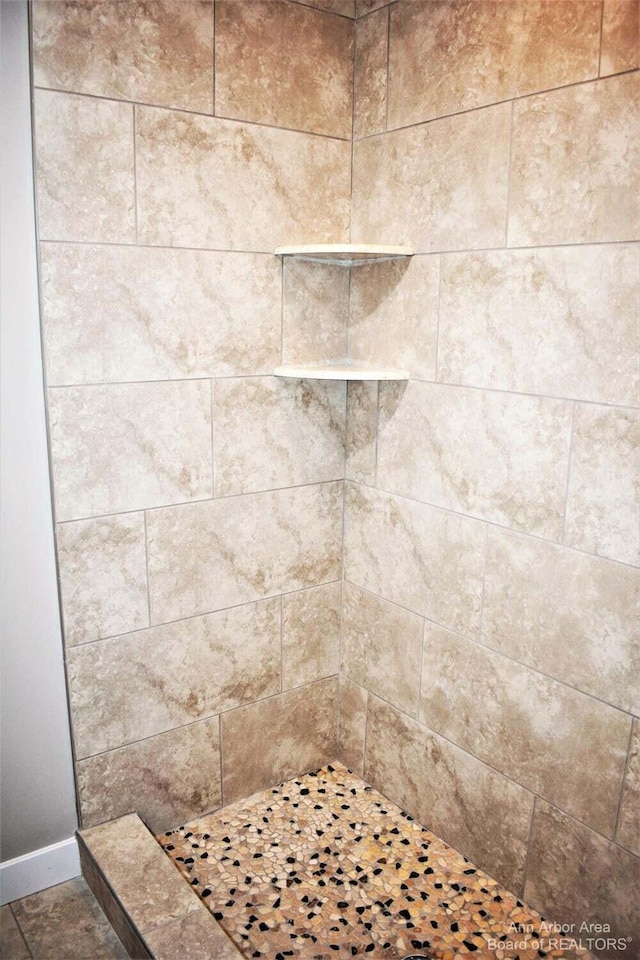 interior details with a tile shower