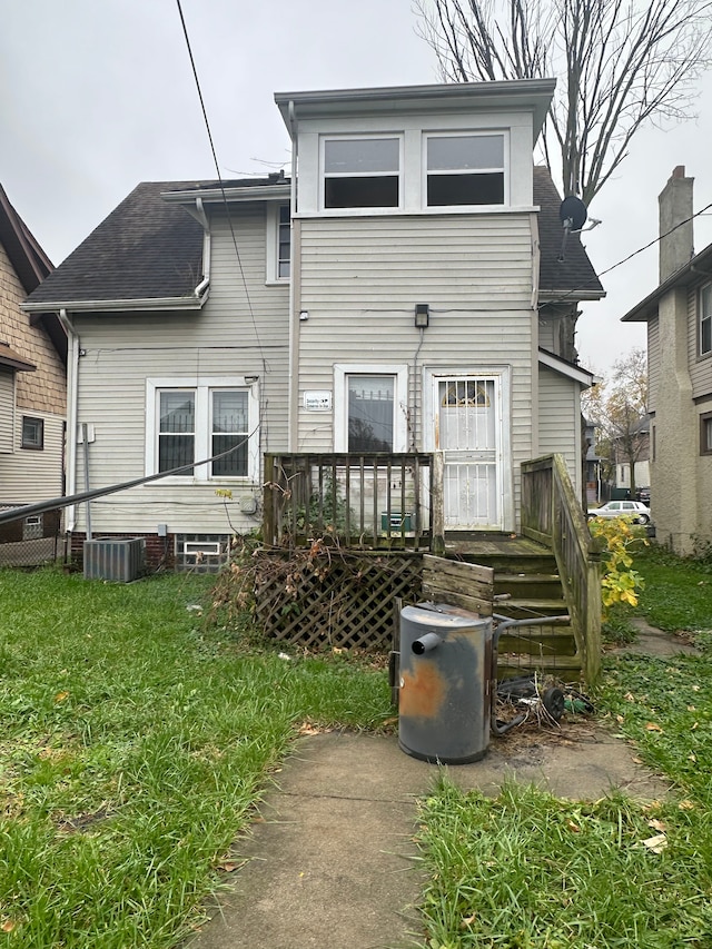 back of house featuring a yard and central air condition unit