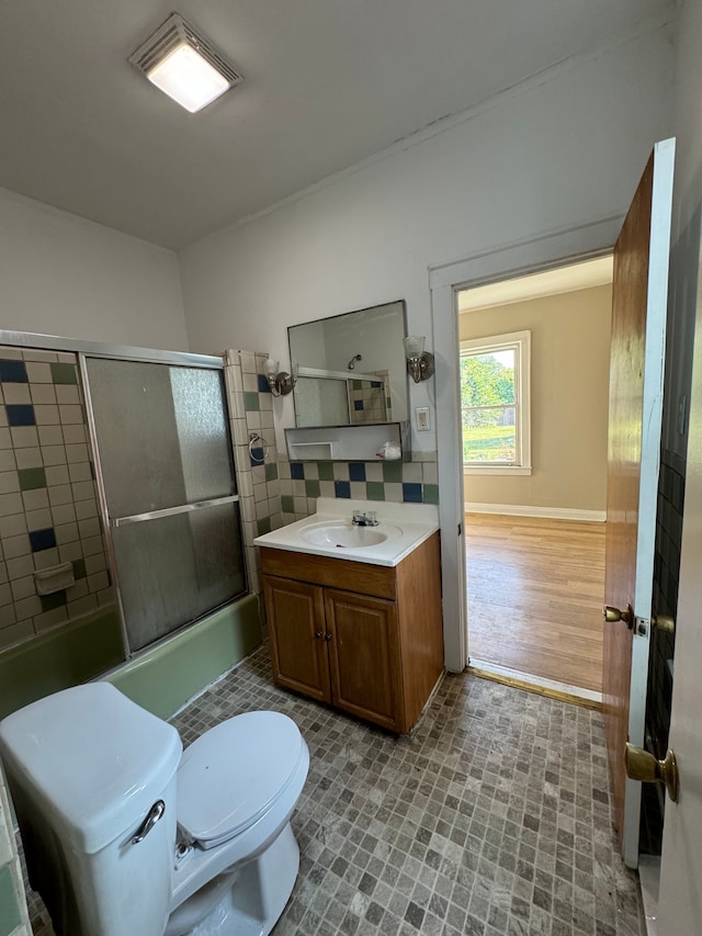 full bathroom with tasteful backsplash, vanity, hardwood / wood-style flooring, enclosed tub / shower combo, and toilet