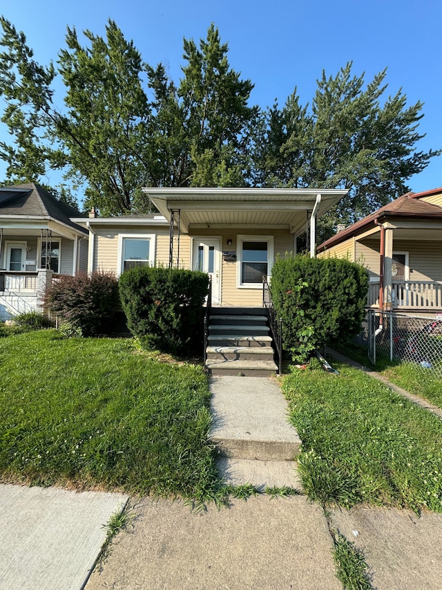 bungalow-style home with covered porch and a front lawn