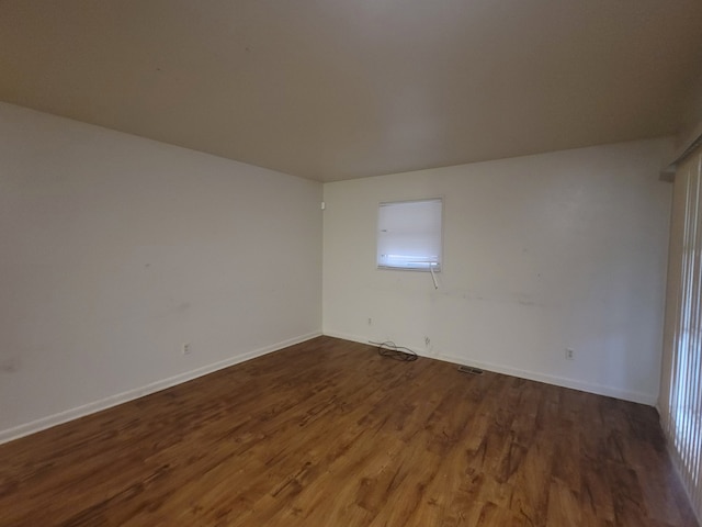 empty room featuring dark hardwood / wood-style flooring