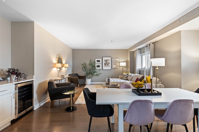 dining space with dark hardwood / wood-style floors and beverage cooler