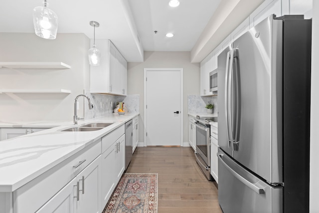 kitchen with white cabinets, dark hardwood / wood-style floors, appliances with stainless steel finishes, and tasteful backsplash