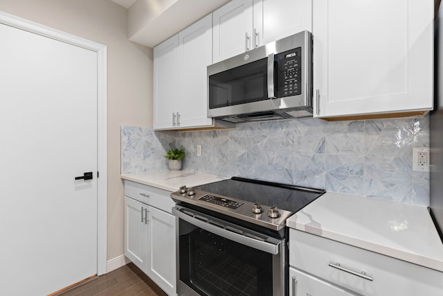 kitchen featuring decorative backsplash, white cabinetry, and appliances with stainless steel finishes