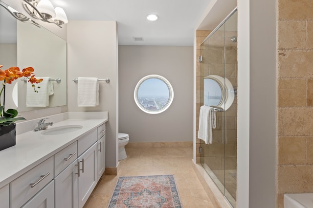 bathroom with tile patterned floors, vanity, a shower with door, a notable chandelier, and toilet