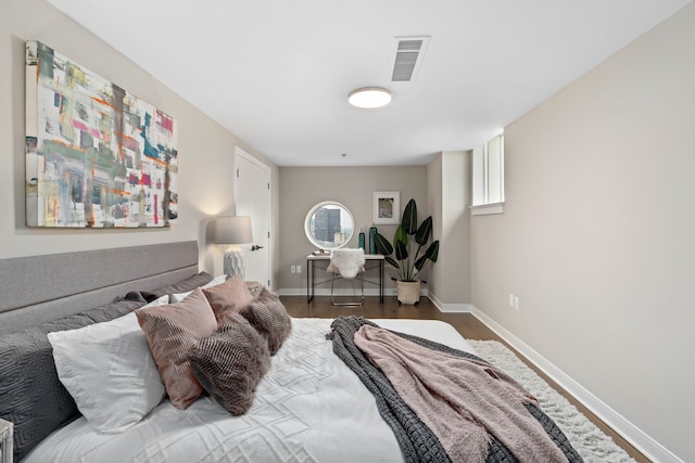 bedroom with dark hardwood / wood-style flooring and multiple windows