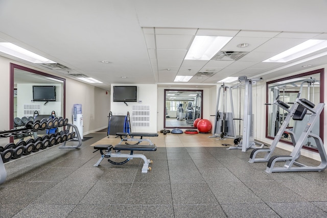 exercise room with a paneled ceiling and plenty of natural light