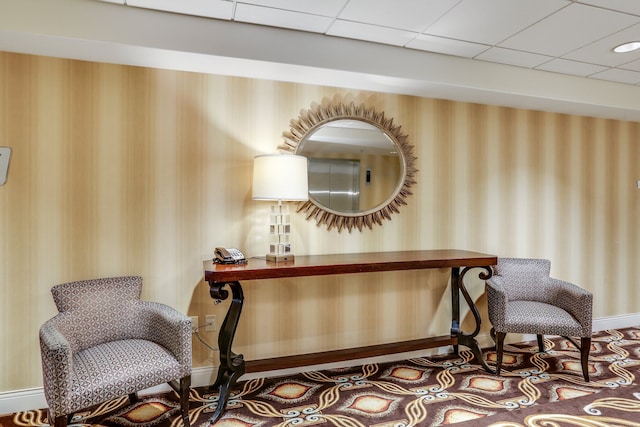 living area with a paneled ceiling