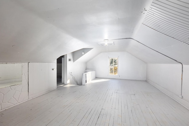 additional living space with light hardwood / wood-style flooring and lofted ceiling