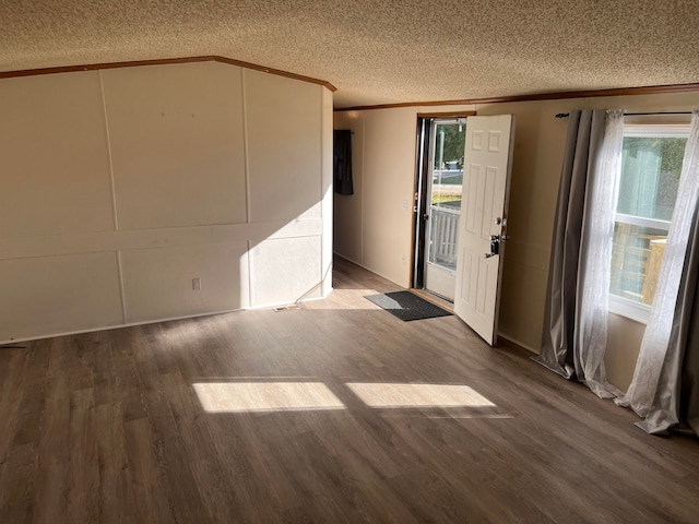 interior space featuring a textured ceiling, wood-type flooring, and ornamental molding