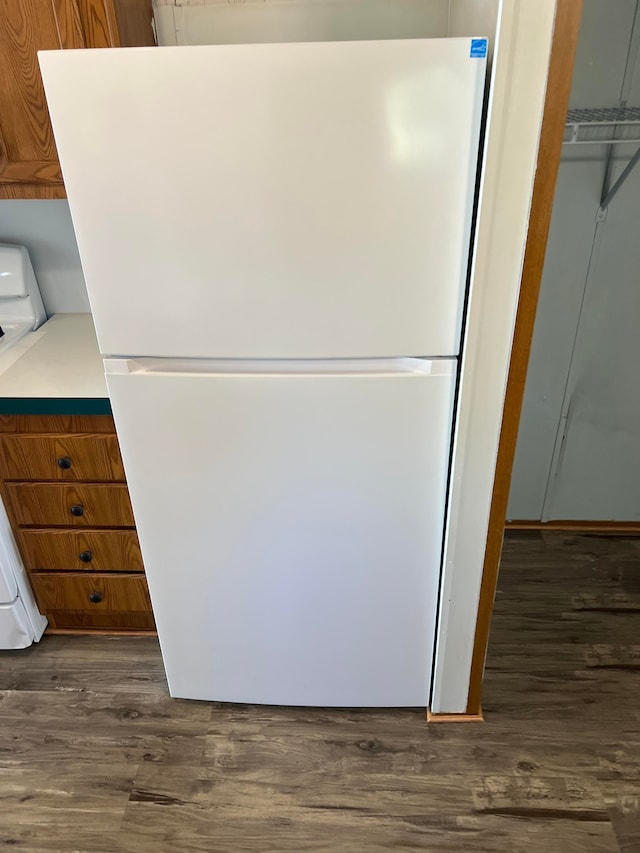 details featuring range, white fridge, and dark wood-type flooring