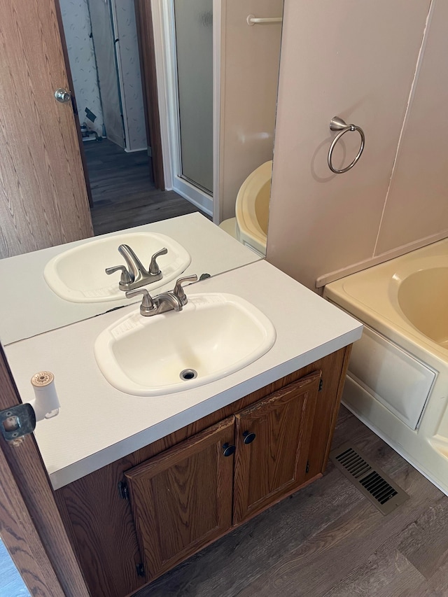 bathroom with vanity, independent shower and bath, and hardwood / wood-style flooring